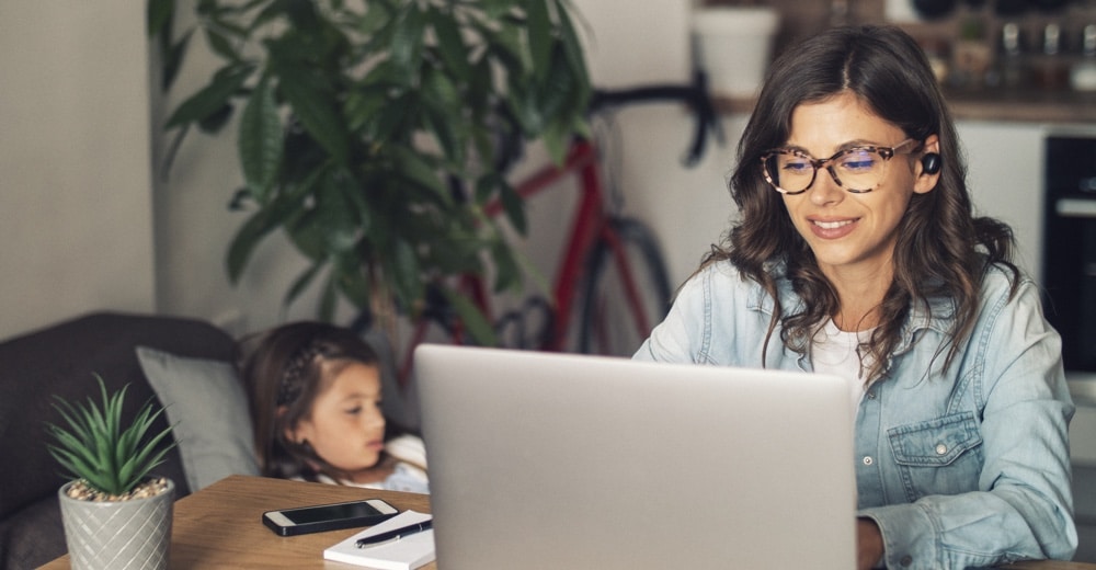 Woman working from home and looking after her child