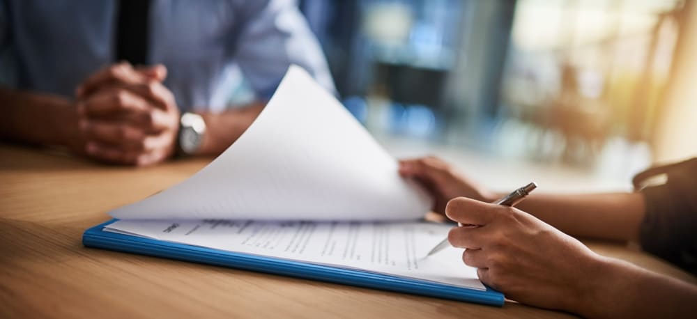 Cropped shot of a man and woman completing paperwork together at a desk