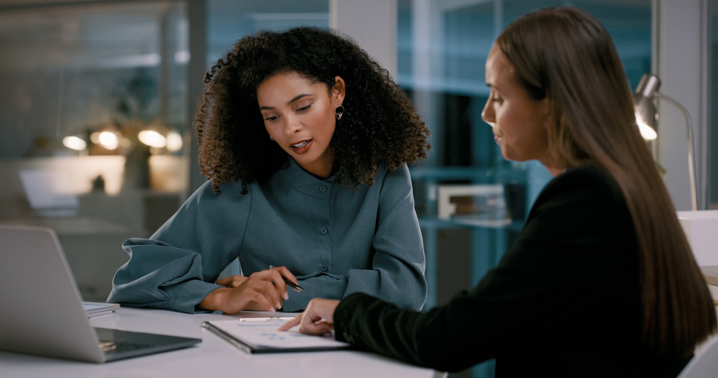 Two business women in a meeting to go over feedback in the office.