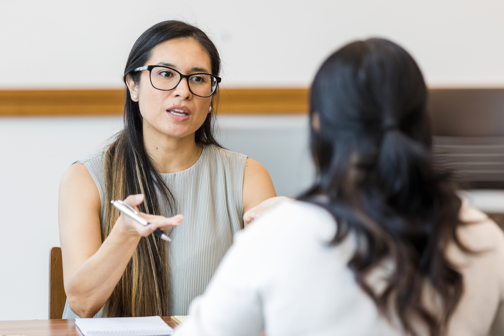 Manager sits with employee to go over performance review in the office.