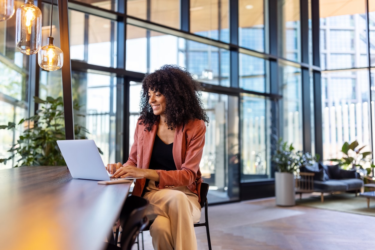 Young woman working on a laptop at an office cafe.