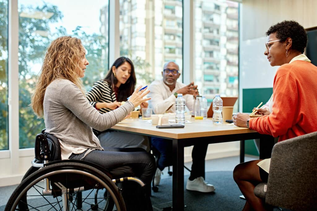 Group of corporate professionals sitting around conference table and discussing ideas