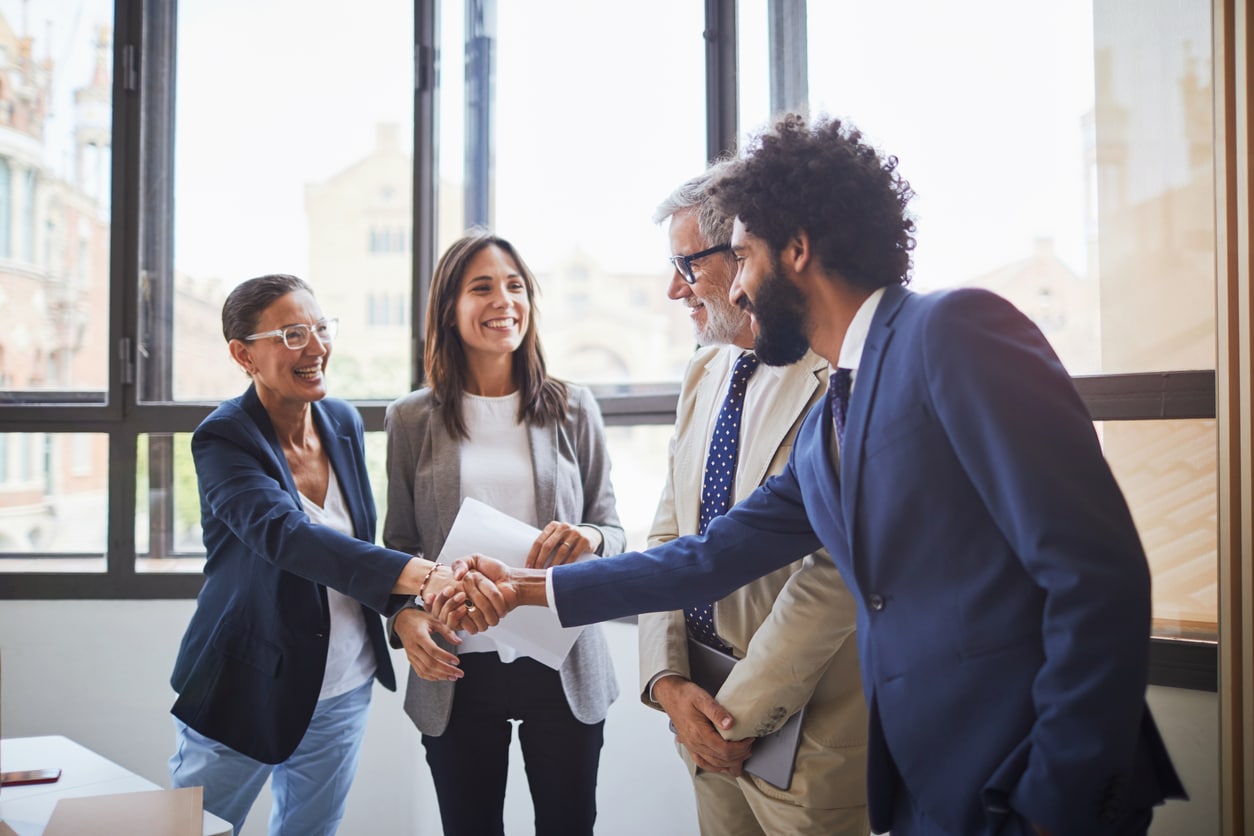 a group of people in a workplace setting shaking hands